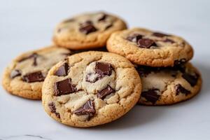 Freshly baked chocolate chip cookies and dark cookies stacked beside a paper bag photo