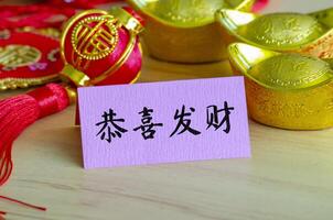 Chinese New Year Greetings and Wishes character on notepad with Chinese New Year decoration. photo