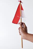 A man's hand raises the red and white flag of the Indonesian nation photo