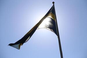 Swedish flag flying in the wind backlit by the sun photo