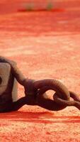 A rusty metal hook on a vibrant red dirt road video