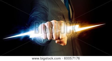 Businessman holding lightning in fist. Power and control