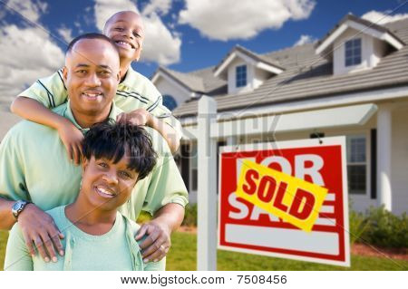 African American Family With Sold For Sale Sign And House