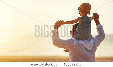 father's day. Dad and baby son playing together outdoors on a summer beach