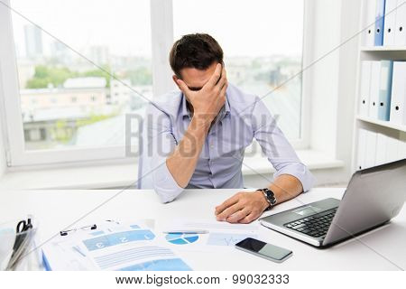 business, people, fail, paperwork and technology concept - businessman with laptop computer and papers working in office