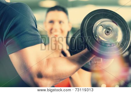 Man or Bodybuilder with his personal fitness trainer in the gym exercising sport with dumbbells, closeup