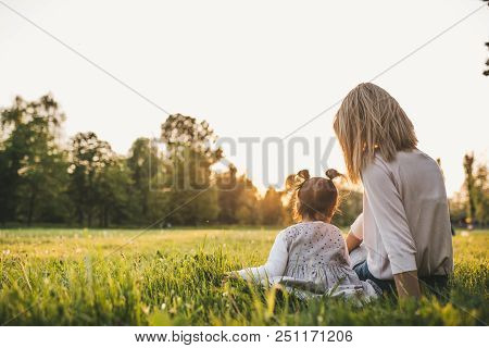 Beautiful Rear View Of Happy Girl Kid Playing With Her Mother Outside. Portrait Of Woman And Her Cut