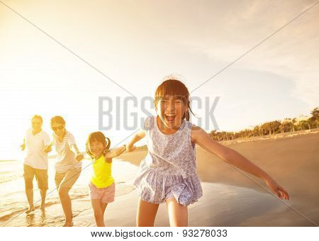 Happy Family Running On The Beach