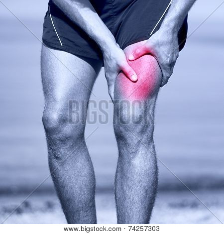 Muscle sports injury of male runner thigh. Running muscle strain injury in thigh. Closeup of runner touching leg in muscle pain.