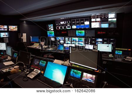 TV Broadcast news studio with many computer screens and control panels for live air broadcast.