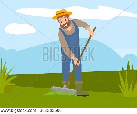 Bearded Farmer In Hat And Overalls Rakes The Grass In Field. Cultivation, Harvesting, Working On Fre