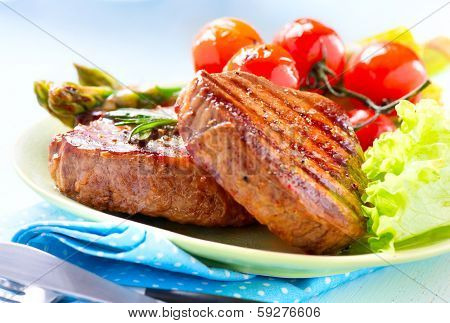 Steak. Grilled Beef Steak Meat with Vegetables - Asparagus, Cherry Tomato and Lettuce. Steak Dinner. Food 