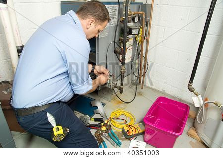 Plumber fixing gas furnace