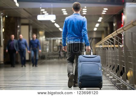 Traveler Pulling Suitcase At Airport