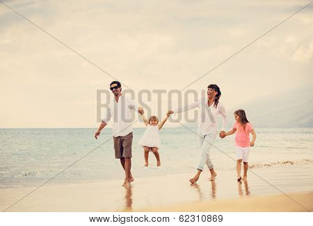 Happy Young Family have Fun Walking on Beach at Sunset