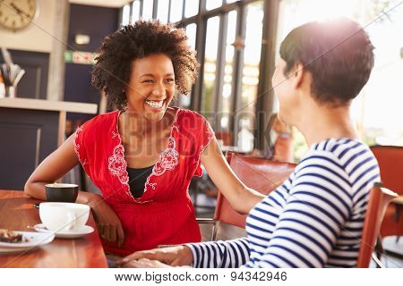 Two female friends talking at a coffee shop