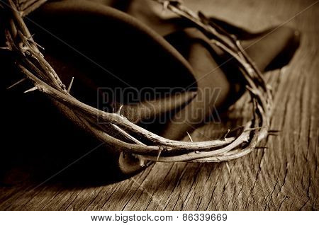 closeup of the crown of thorns of Jesus Christ on a rustic wooden surface, in sepia toning