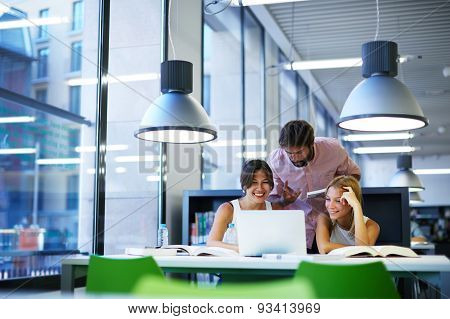 International university students having fun studying in library while sitting at the desk table