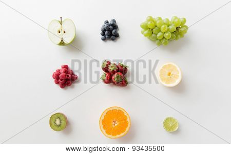 diet, eco food, healthy eating and objects concept - ripe fruits and berries on white surface