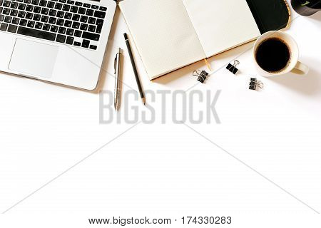 Modern minimalistic work place. White office desk table with laptop, coffee cup, clips, notebook, pen and penclil. Top view with copy space, flat lay