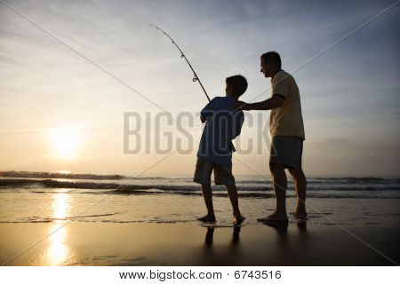 Mann und Young Boy Angeln in surf