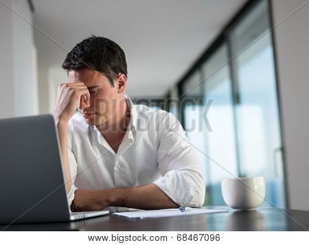 frustrated with problems young business man working on laptop computer at home