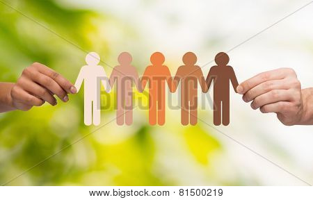 community, unity, people and support concept - couple hands holding paper chain multiracial people over green background