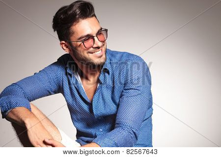 Portrait of a handsome fashion man smiling while looking away from the camera.