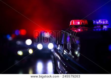 Police Car Chasing A Car At Night With Fog Background. 911 Emergency Response Police Car Speeding To