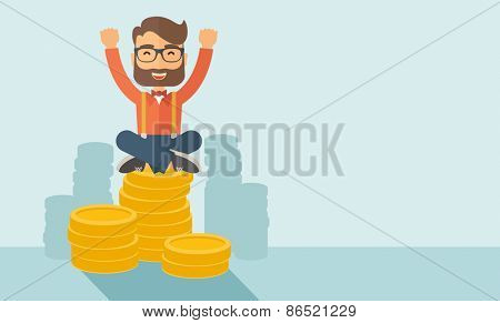 An overjoyed young hipster Caucasian man with beard sitting on the top of coins. Raising his two hands to show that he is a winner. Happy, winner concept. A contemporary style with pastel palette