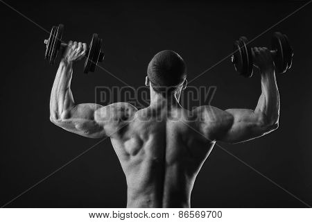 Man makes exercises dumbbells.