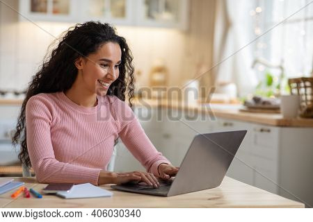 Remote Work. Beautiful Young Freelancer Lady Working With Laptop In Kitchen, Happy Millennial Woman 