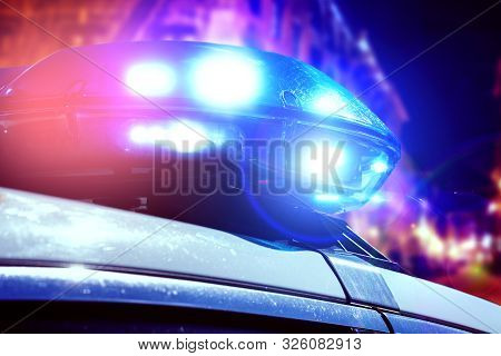 Blue And Red Light Flasher Of A Patrol Police Car At Night. Police Force Department In Full Activity