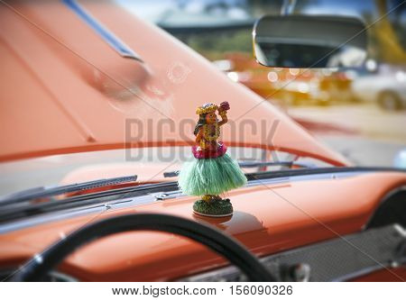 Hula girl statuette on dashboard of a vintage antique car