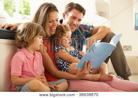 Parents Sitting With Children Reading Story Indoors