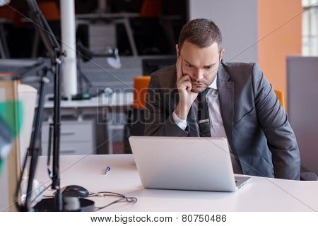 frustrated young business man working on laptop computer at office