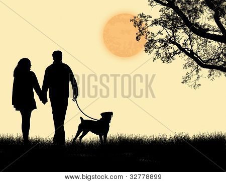 Silhueta de um casal andando seu cachorro no Sunset