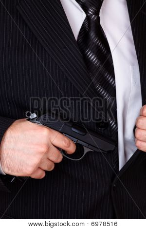 Man Drawing His Gun From Jacket Pocket