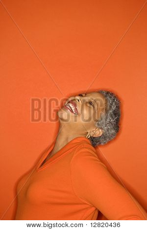 African American mature adult female with head back smiling.