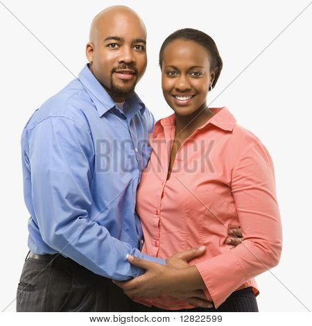 Portrait of African American couple with arms around eachother against white background.