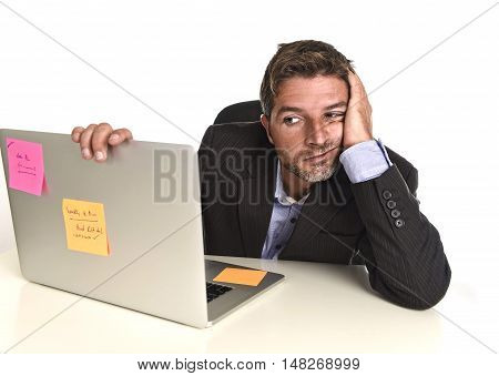 young attractive businessman looking worried face expression suffering stress at office laptop computer having work problem sitting on desk frustrated and bored isolated on white background