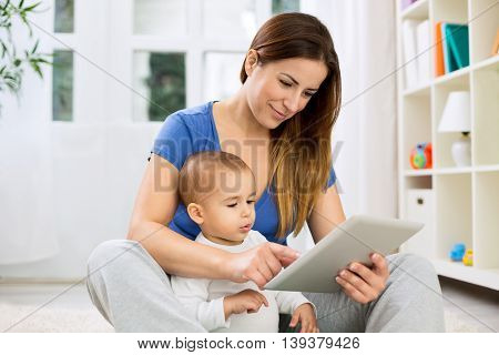 Young Mother Larning Child How To Use Tablet