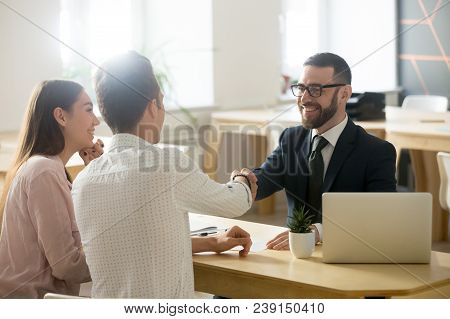 Smiling Lawyer, Realtor Or Financial Advisor Handshaking Young Couple Thanking For Advice, Insurance