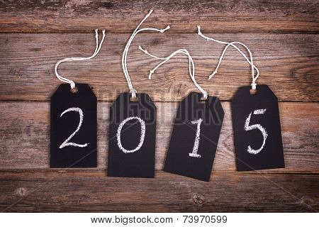 Chalkboard gift tags with strings, over old wood background, 2015 written in white chalk. New Year 2015 concept. 