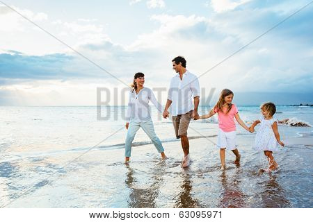 Happy young family walking on the beach at sunset. Happy Family Lifestyle 