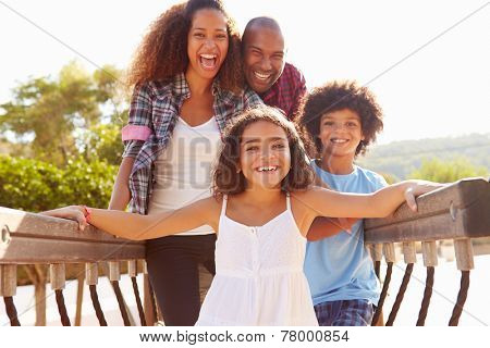 Portrait Of Family On Playground Climbing Frame