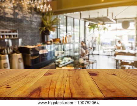 Wooden board empty table in front of blurred background. Perspective brown wood over blur in coffee shop or cafe and restaurant- can be used for display or montage your products.Mock up your products.