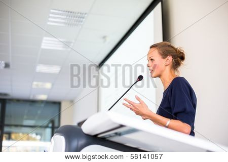 Pretty young business woman giving a presentation in a conference/meeting setting (shallow DOF; color toned image)