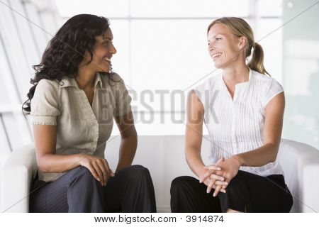 Middle Eastern / Western Business Women Sat On Sofa