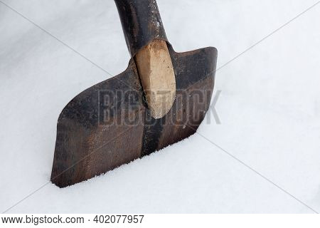 Close-up Shovel Stuck In A Snowdrift. Snow Removal After Heavy Snowfall